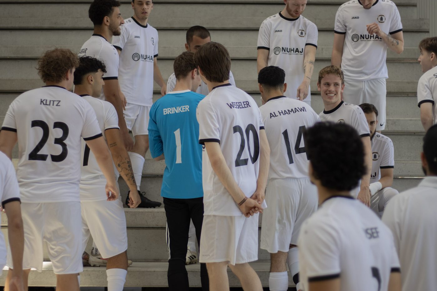 Mannschaft vor dem Teamfoto auf der Tribüne